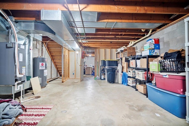 unfinished basement with water heater, stairway, and heating unit