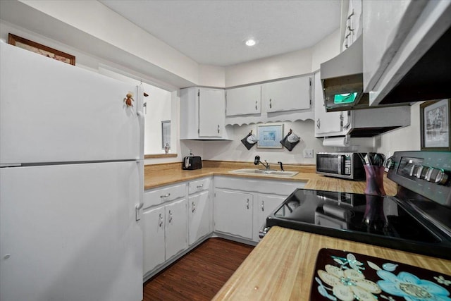 kitchen with stainless steel microwave, freestanding refrigerator, electric stove, white cabinets, and a sink