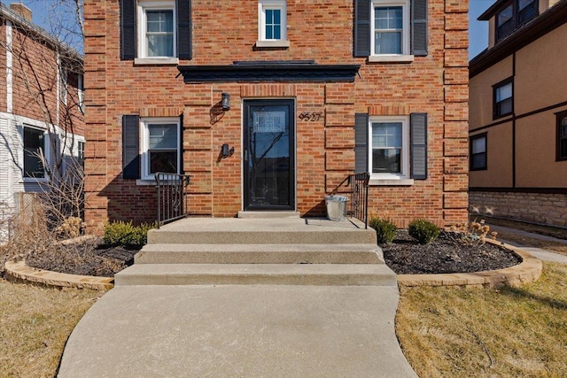 property entrance featuring brick siding