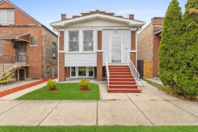 view of front facade with brick siding, a chimney, and fence