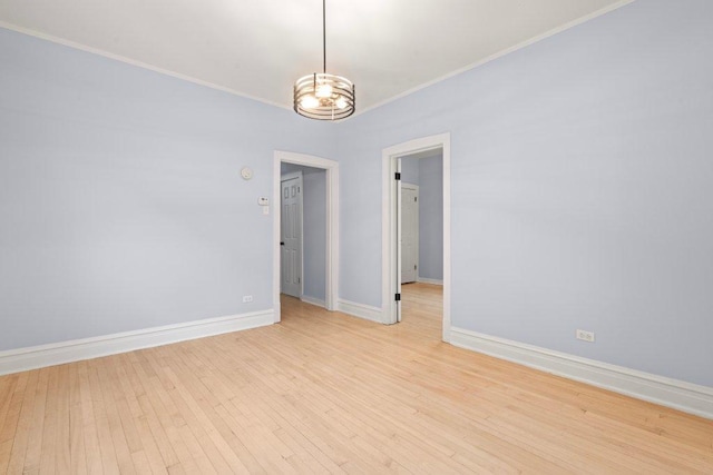 unfurnished room with crown molding, light wood-style floors, and baseboards