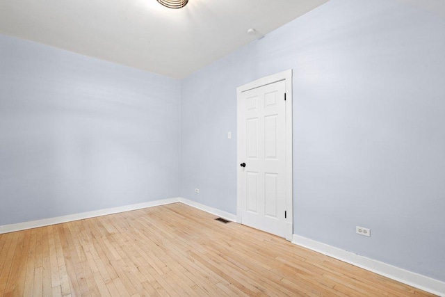 empty room with light wood-type flooring, baseboards, and visible vents