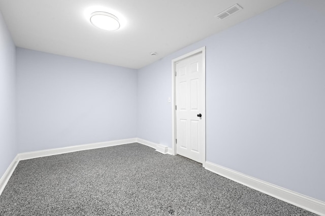 spare room with baseboards, visible vents, and dark colored carpet