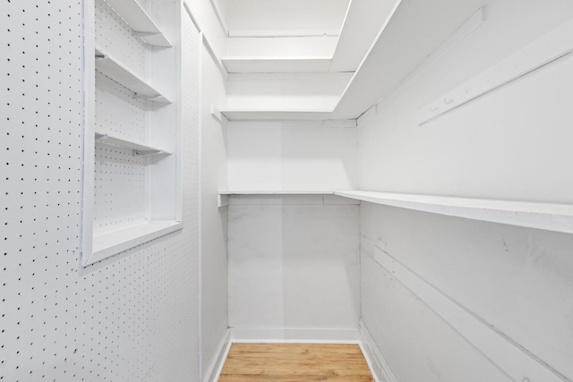 walk in closet with wood finished floors