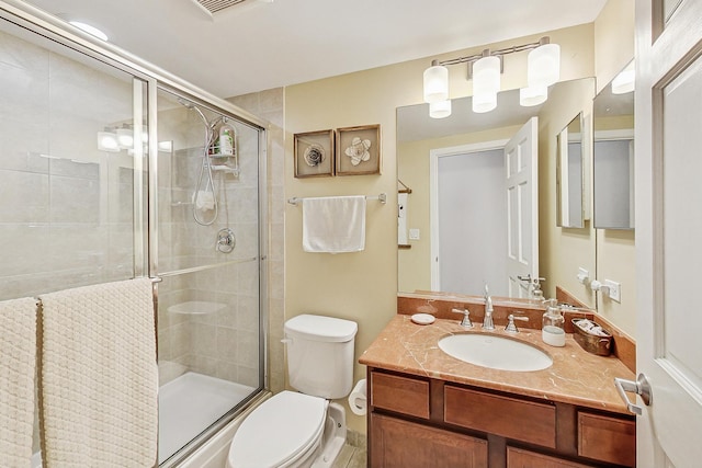 full bathroom with a stall shower, toilet, and vanity