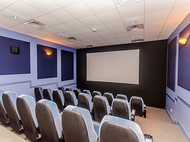 carpeted home theater featuring a drop ceiling and visible vents