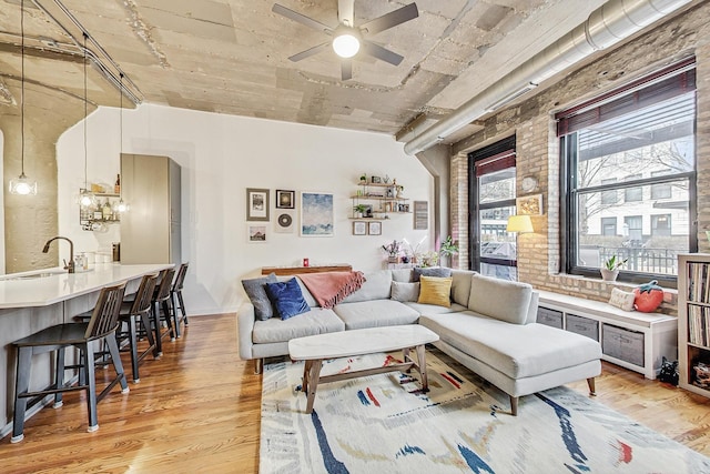 living area with light wood-style flooring and a ceiling fan