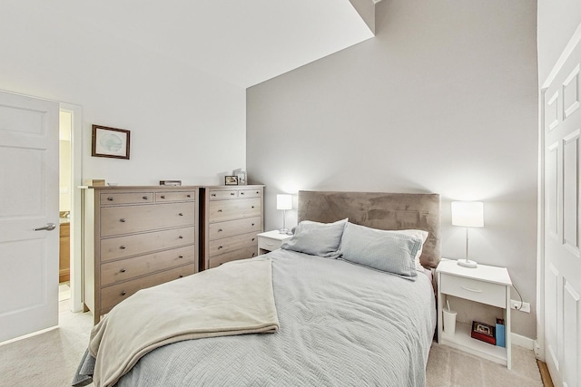 bedroom with vaulted ceiling, baseboards, and light carpet