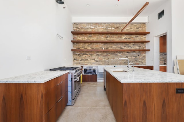 kitchen featuring a sink, brown cabinets, modern cabinets, and high end stainless steel range