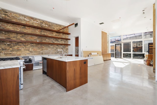 kitchen with stainless steel gas range oven, visible vents, modern cabinets, finished concrete floors, and open floor plan