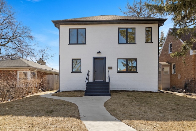 view of front of home with brick siding and a front lawn