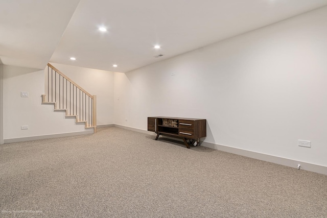 finished below grade area featuring stairway, carpet floors, baseboards, visible vents, and recessed lighting