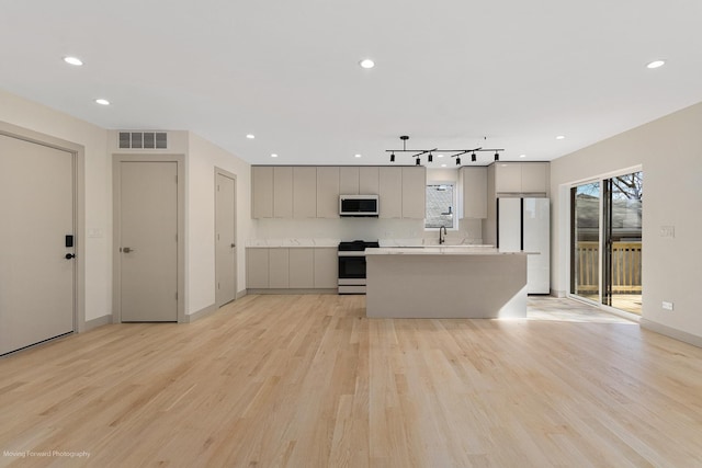 kitchen featuring visible vents, light wood finished floors, gray cabinetry, and white appliances