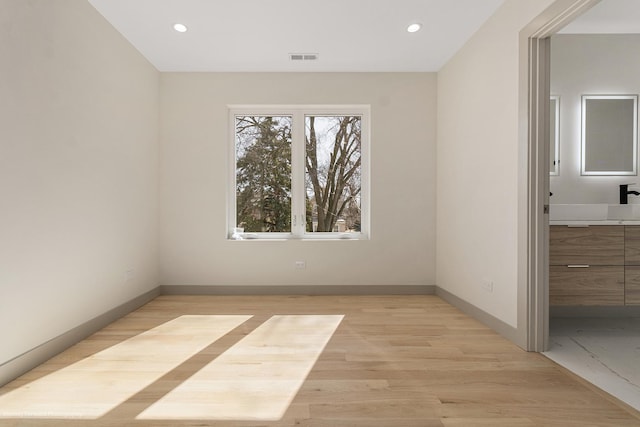 empty room featuring baseboards, recessed lighting, and light wood-style floors