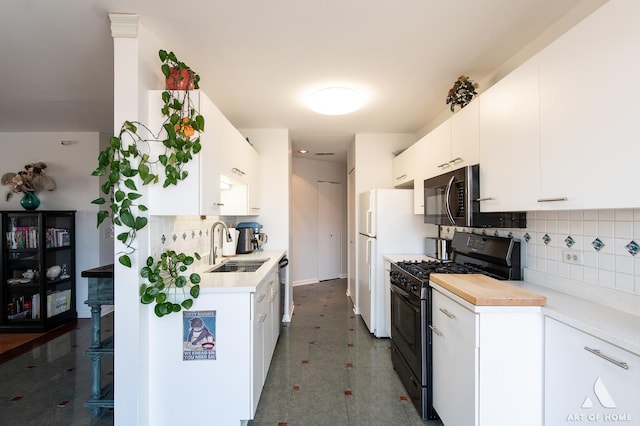 kitchen featuring a sink, light countertops, white cabinets, black range with gas stovetop, and tasteful backsplash