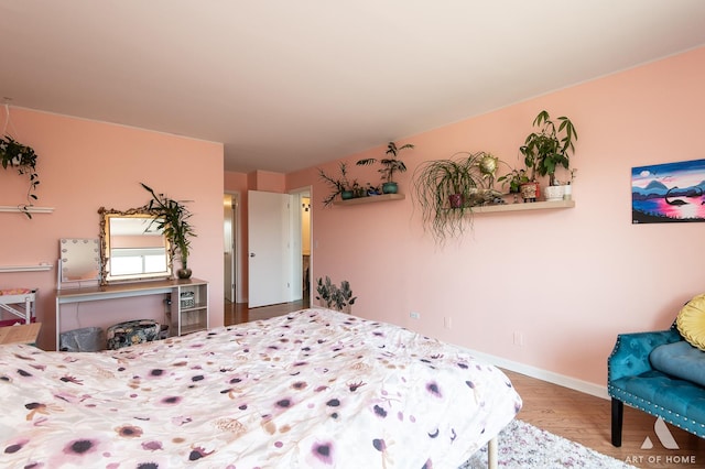 bedroom featuring baseboards and wood finished floors