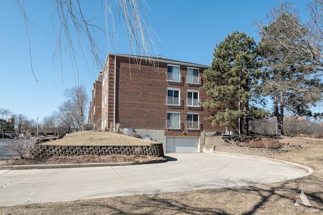 view of building exterior with concrete driveway and an attached garage