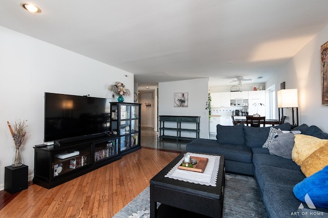 living area with a ceiling fan and wood finished floors