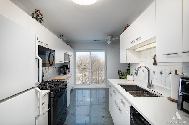 kitchen with a ceiling fan, a sink, black appliances, light countertops, and white cabinetry