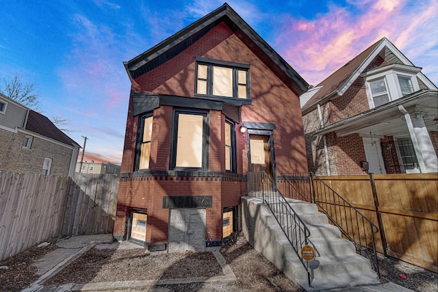 view of front of home featuring brick siding and fence private yard