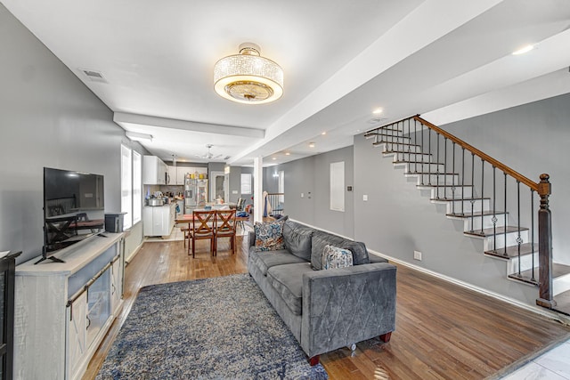 living area with stairway, baseboards, visible vents, light wood finished floors, and recessed lighting