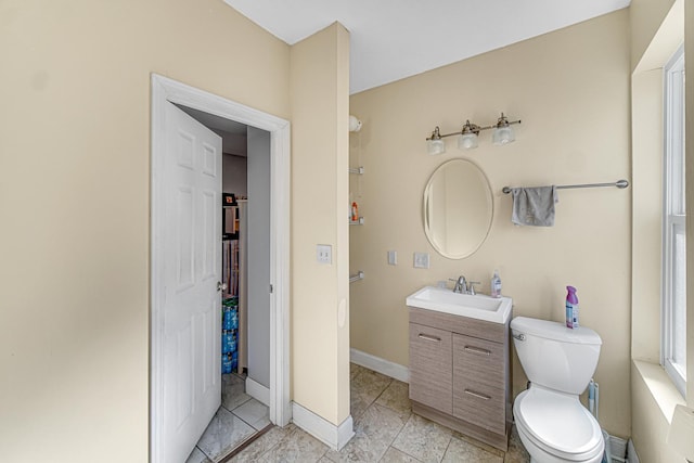 bathroom featuring baseboards, toilet, and vanity