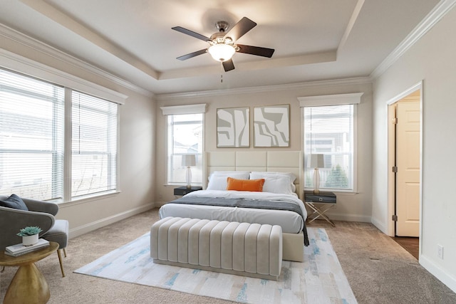 bedroom featuring multiple windows, a raised ceiling, baseboards, and ornamental molding