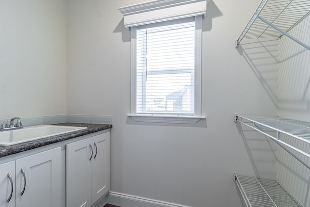 interior space featuring baseboards and a sink