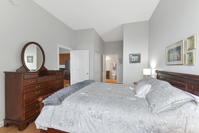 bedroom with light wood-style flooring and connected bathroom