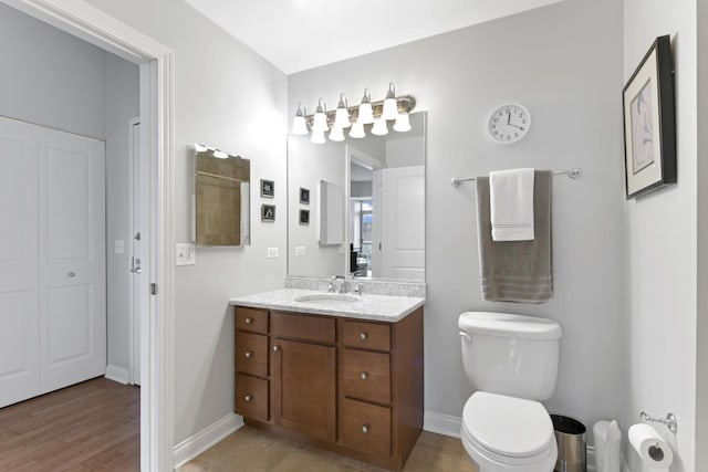 bathroom with vanity, toilet, and baseboards