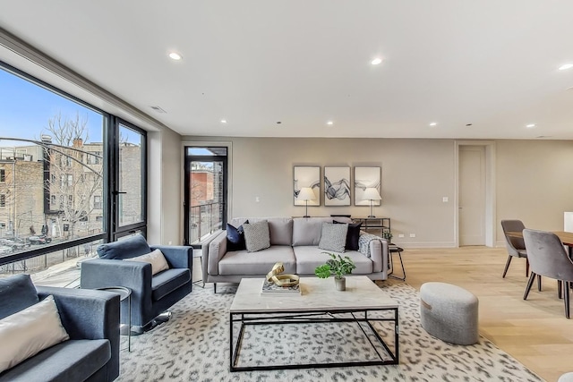 living room with recessed lighting, light wood-style flooring, visible vents, and baseboards