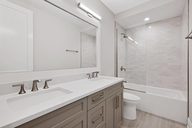 bathroom with a sink, toilet, bathtub / shower combination, and double vanity