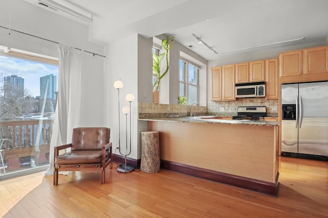 kitchen with visible vents, light brown cabinets, tasteful backsplash, stainless steel appliances, and light wood-style floors