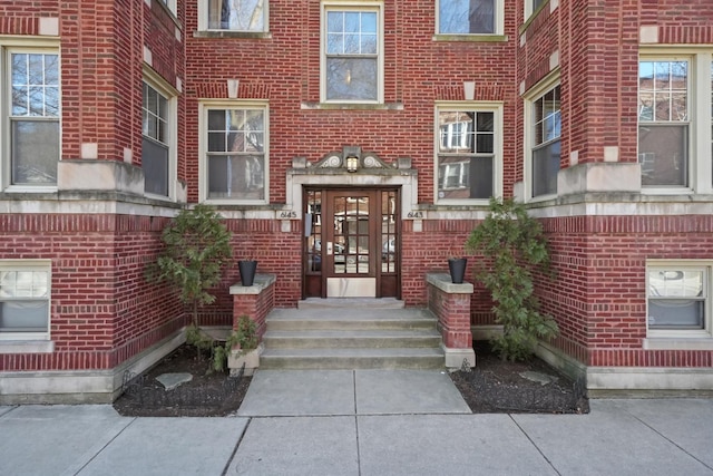 entrance to property featuring french doors and brick siding