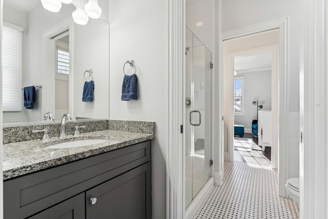 ensuite bathroom with toilet, a stall shower, vanity, and ensuite bathroom