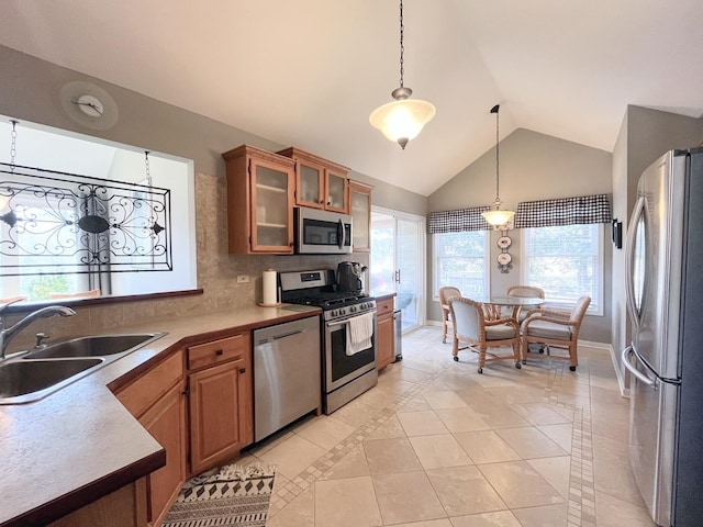 kitchen with a sink, decorative light fixtures, tasteful backsplash, stainless steel appliances, and baseboards