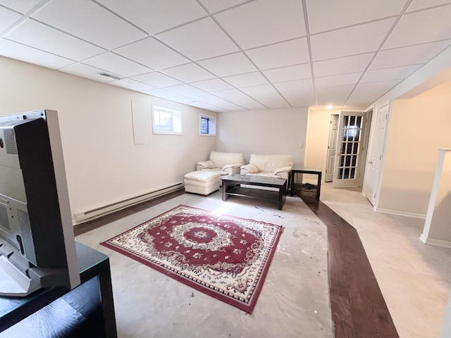 living room with a drop ceiling, baseboards, visible vents, and a baseboard radiator