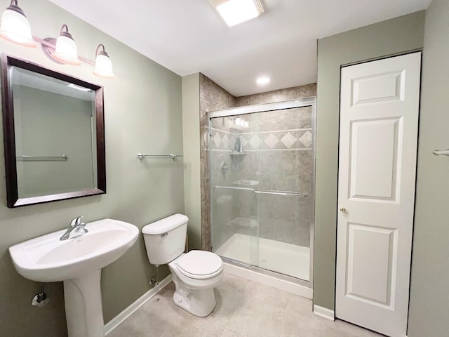 full bathroom with tile patterned flooring, a shower stall, baseboards, toilet, and a sink