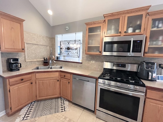 kitchen featuring light brown cabinetry, a sink, appliances with stainless steel finishes, light countertops, and vaulted ceiling