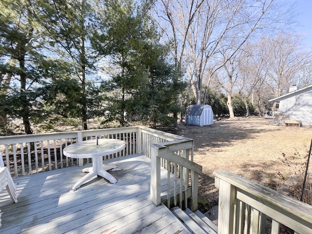 wooden deck with an outdoor structure and a storage unit