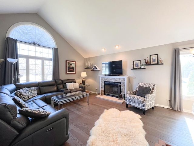 living room with high vaulted ceiling, a fireplace, dark wood-style flooring, and baseboards