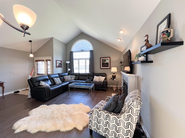 living area with a fireplace, lofted ceiling, wood finished floors, and baseboards