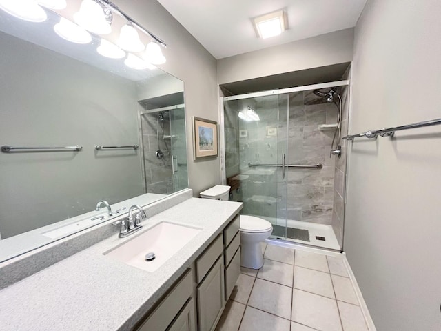 bathroom featuring vanity, baseboards, a shower stall, tile patterned floors, and toilet