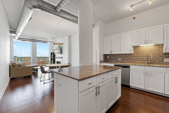 kitchen with a sink, tasteful backsplash, white cabinets, dishwasher, and dark wood-style flooring