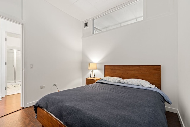 bedroom featuring visible vents, baseboards, and wood finished floors