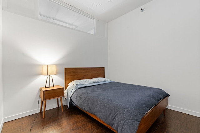 bedroom with baseboards and wood finished floors