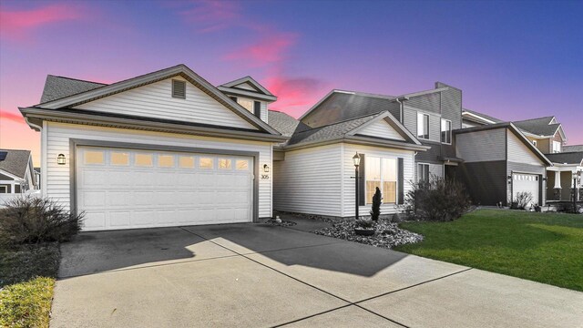 view of front of home featuring a garage, concrete driveway, and a front yard