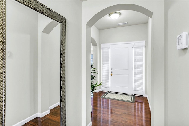 foyer entrance with visible vents, baseboards, and wood finished floors