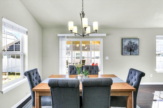 dining room featuring an inviting chandelier, wood finished floors, baseboards, and a wealth of natural light