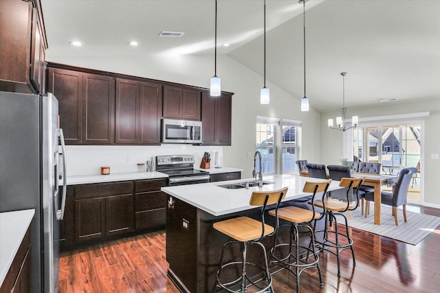 kitchen with visible vents, a breakfast bar, light countertops, stainless steel appliances, and a sink